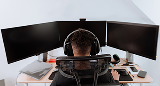 Image of person sat with 3 monitors