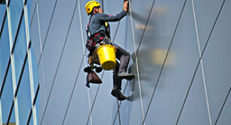 Image of Man cleaning the windows of a high-rise building