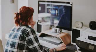 Image of Lady sitting in home office working on her computer.